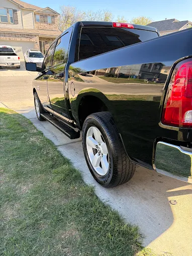 Black Ram pickup truck with a mirror-like ceramic-coated finish in a San Antonio driveway