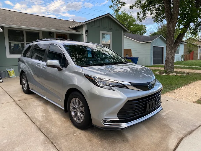 Silver Toyota Sienna minivan with restored gloss in a residential driveway after mobile paint enhancement